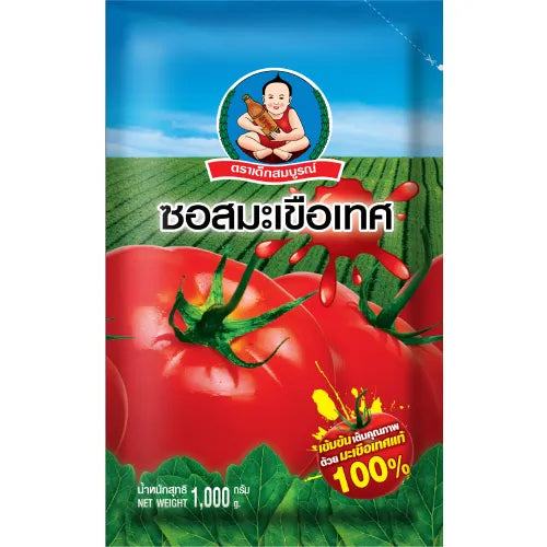 Bottle of DEKSOMBOON Tomato Sauce, 1000g, with red tomato labels and clear cap, on a kitchen countertop.