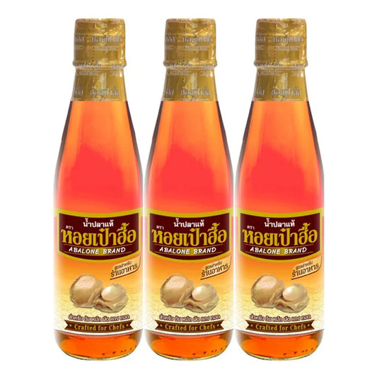 ABALONE Premium Fish Sauce 700 ml bottles, clear glass with dark liquid, label featuring fish imagery, on a kitchen countertop.