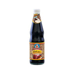 Deksomboon Black Soy Sauce 970g bottle from the dry grocery section, showing the dark soy sauce in a clear plastic bottle.