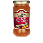Jar of Filippo Berio Tomato Pesto with basil and olive oil, showing the label and fresh ingredients inside the jar.
