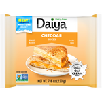 Sliced Daiya Vegan Cheddar Cheese on a plate, showcasing its vibrant orange color and smooth texture.