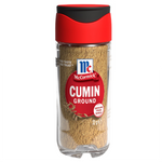 Ground McCormick cumin spice in a clear glass jar, showing the brownish-green powder inside.
