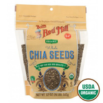 Close-up of Bob's Red Mill Organic Chia Seeds in a clear glass jar, highlighting the small, black and white seeds on a white background.