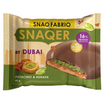 Snaqer pistachio and kunafa confectionery snacks in a clear plastic container, showcasing the textured, nut-filled treats.