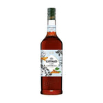 Giffard Barista Cinnamon 1L bottle, dry grocery product with cinnamon flavor, shown in clear plastic container on a countertop