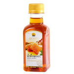 Jar of Doi Kham 100% honey with golden color, showcasing smooth texture and natural honey product from the Doi Kham grocery brand.