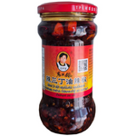 Laoganma chili sauce with peanuts in a jar, popular grocery condiment with spicy and savory flavors, ready for cooking or dipping.