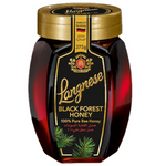 Jar of Langnese Black Forest Honey from the grocery section, showing golden honey with a clear label and lid.