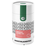 Glass of Northlandtea Organic Lychee Tea with fresh lychee fruit and tea leaves on a white background.