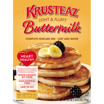 Krusteaz Buttermilk Light & Fluffy Pancake mix box with pancakes stacked on a plate, showcasing golden, fluffy pancakes ready to eat.