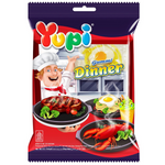Colorful Yupi Gummy Dinner confectionery snacks in a variety of fruit-shaped gummy candies arranged on a white background.
