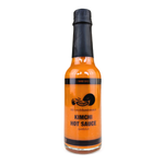 Bottle of The Serial Pickler Kimchi Hot Sauce, a spicy grocery condiment with vibrant label and squeeze-top packaging.