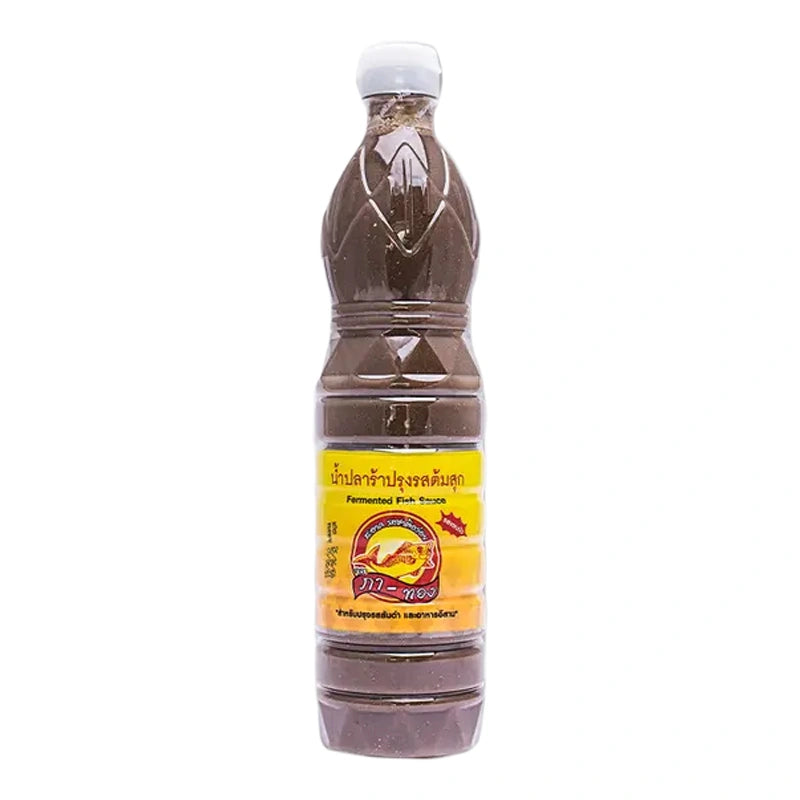 Bottle of PA-THONG Fermented Fish Sauce 750ml, clear glass container with dark liquid, label visible, on a kitchen surface.