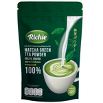 Richie Matcha Green Tea Powder in a glass drink showcasing vibrant green color with a frothy top.