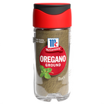 Dried McCormick oregano in a glass jar, fresh green leaves with small dried herbs, for culinary use in cooking and seasoning.
