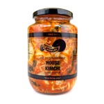 Jar of The Serial Pickler House Kimchi with fresh vegetables and spices in a glass container, showcasing traditional Korean fermented kimchi.