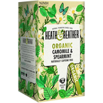 Heath & Heather Organic Camomile and Spearmint Tea in a glass cup with fresh herbs on a wooden table.