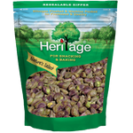 Heritage Pistachios in a clear bowl, showcasing vibrant green and brown roasted pistachio nuts, ideal for confectionery snacks.