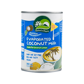 Cans of Nature's Charm evaporated coconut milk, healthy dairy alternative with creamy texture, on a white background.