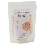 Kurera Himalayan Crystal Pink Salt in a clear container, showcasing pink salt crystals used for cooking and seasoning.