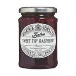 Jar of Tiptree Raspberry Preserve showing fresh raspberries and rich jam inside a glass jar
