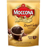 Moccona Royal Gold instant coffee drink served in a glass cup with a frothy top and caramel color liquid.