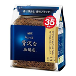A cup of Maxim Special Bland instant coffee drink with a spoon, showcasing the product's creamy and smooth coffee appearance.