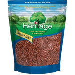 Heritage Flax Seeds in a clear glass jar, showcasing small golden seeds on a white background for healthy eating.