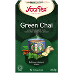 A cup of Yogi Green Chai herbal tea in a clear glass, showing the vibrant green tea leaves and brewed beverage inside.