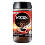 Nescafe Red Cup instant coffee drink in a glass mug with a spoon, showcasing the beverage's rich, dark color.
