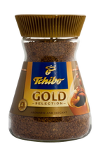 A steaming cup of Tchibo Gold Selection Coffee drink in a white mug, showcasing rich, golden-brown coffee with a smooth surface.